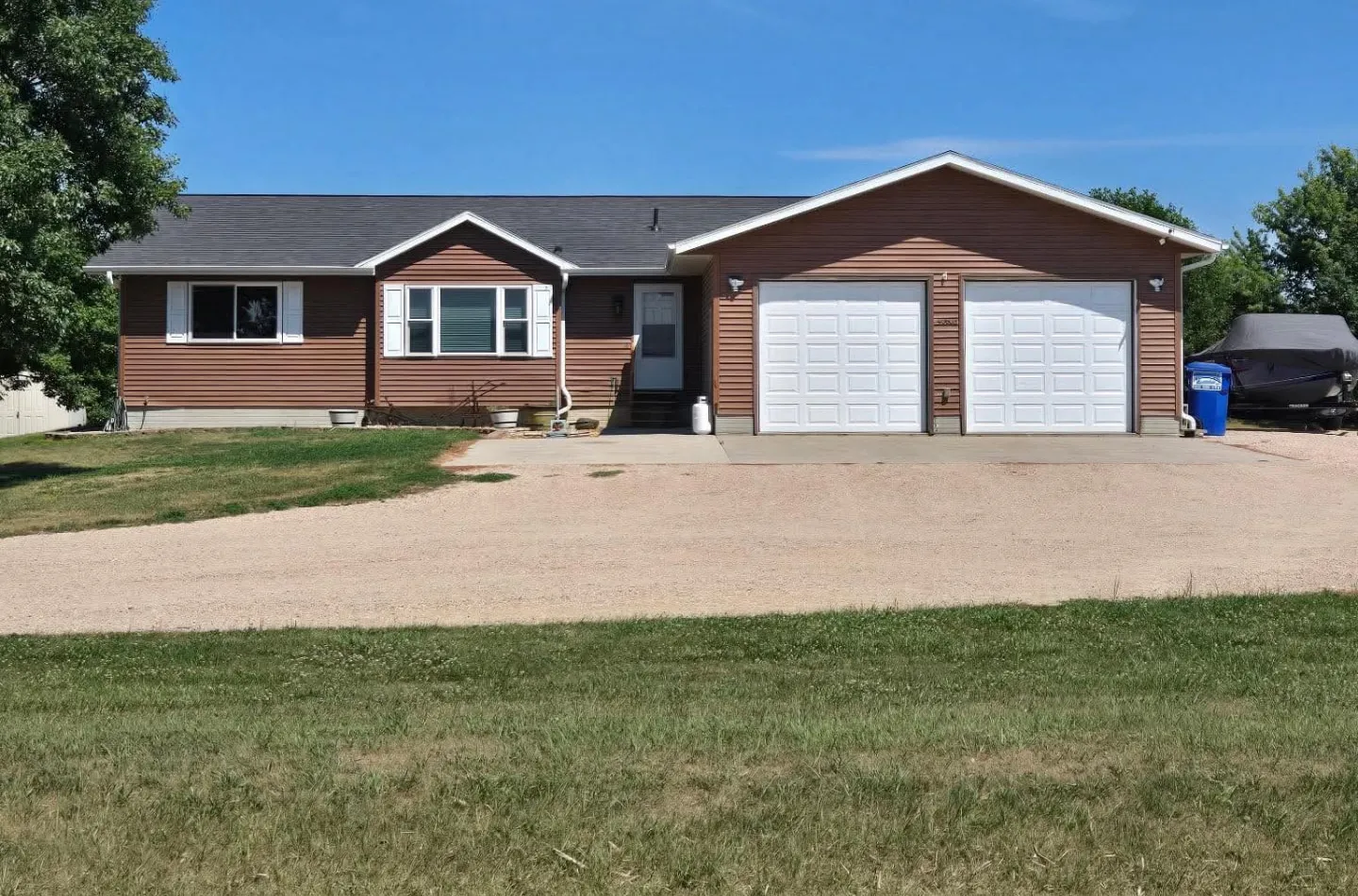 Ranch home with brown lap siding and a two-stall attached garage