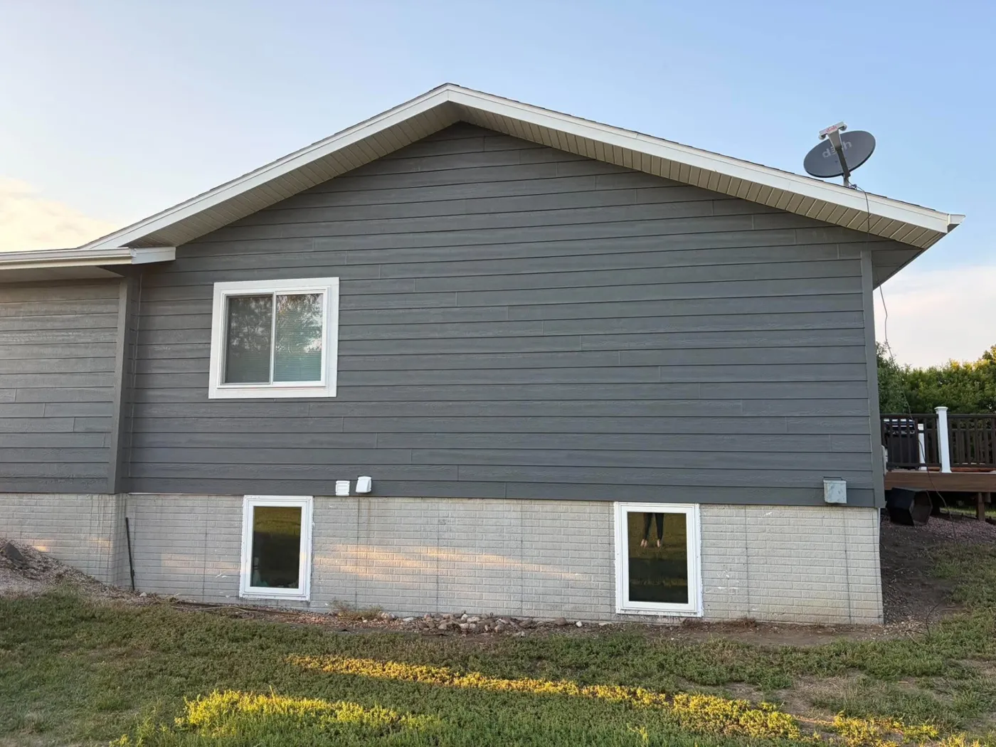 Home with new gray lap siding and white window trim