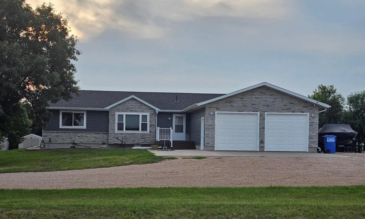 Gray ranch home with attached two-stall garage and stone front